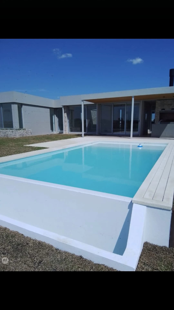 Piscina elevada en casa minimalista moderna con agua turquesa