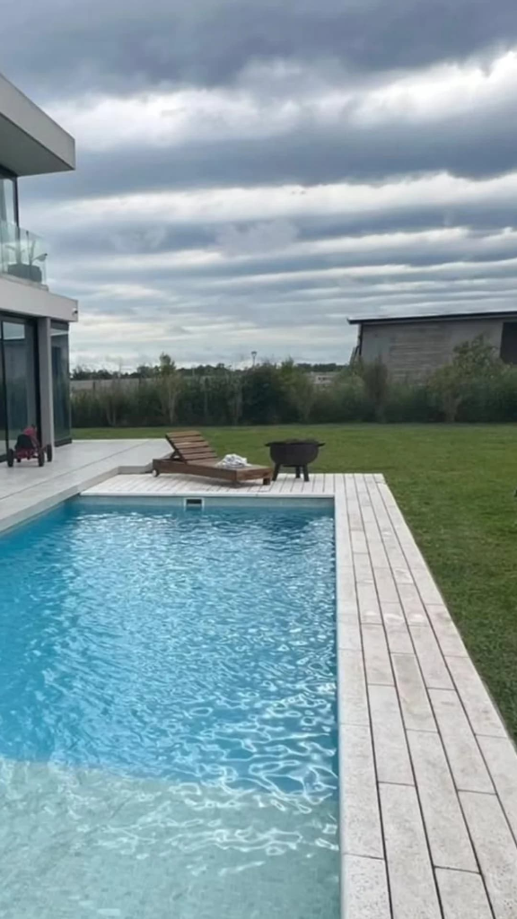 Piscina rectangular con deck atérmico y reposera bajo cielo abierto