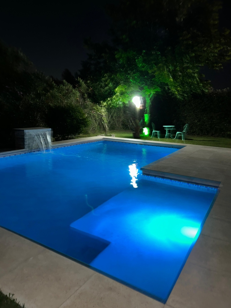 Pileta nocturna con cascada e iluminación LED verde y azul