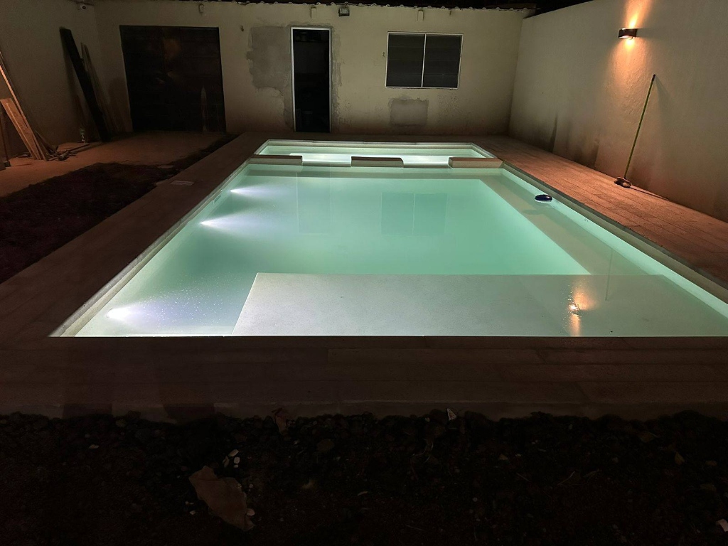 Pileta nocturna con revestimiento blanco e iluminación LED menta